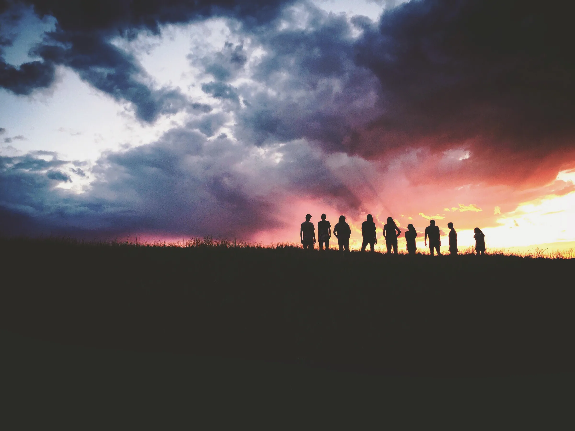 Vier Freunde stehen Arm in Arm im Abendlicht