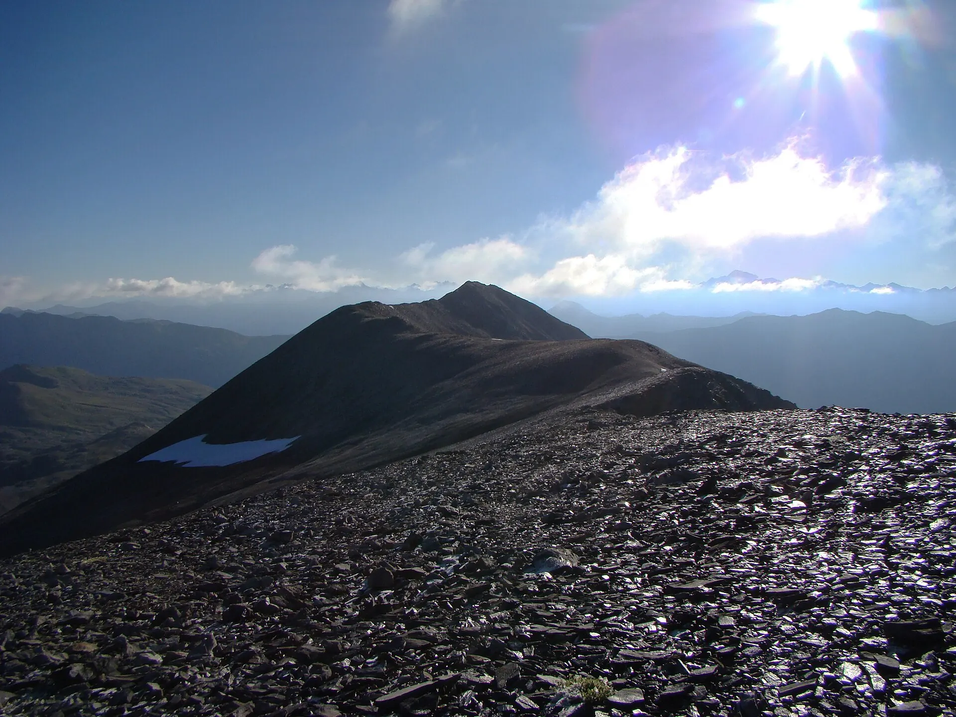 Bergkamm mit kleinem Bergsee im Gegenlicht